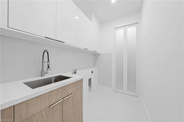 Washroom with cabinet space, hookup for a washing machine, and recessed lighting