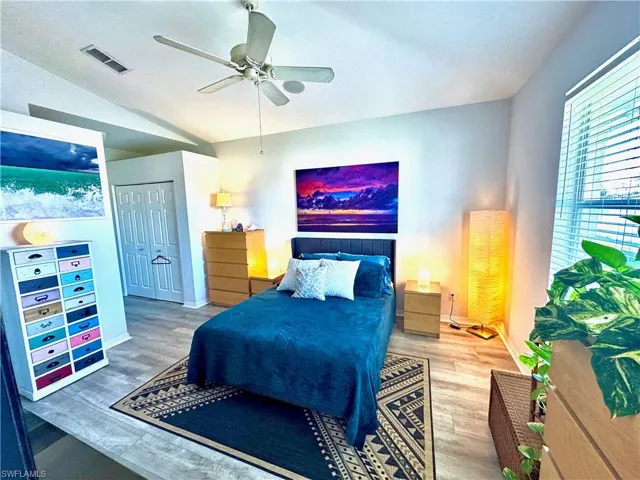Bedroom with ceiling fan, wood-type flooring, and vaulted ceiling