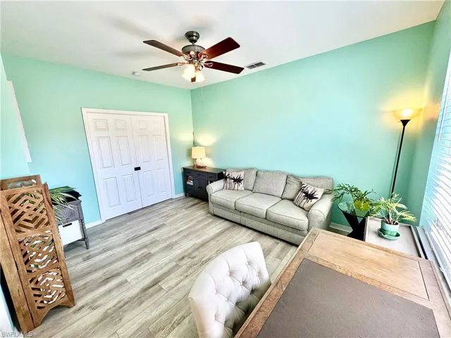 Living room featuring ceiling fan and wood-type flooring