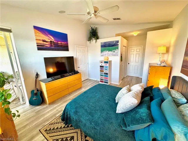 Bedroom with lofted ceiling, ceiling fan, and light wood-type flooring
