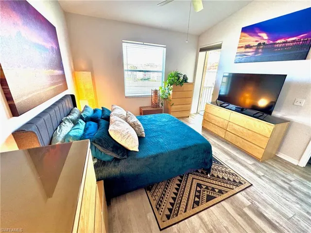 Bedroom with hardwood / wood-style flooring, ceiling fan, and vaulted ceiling