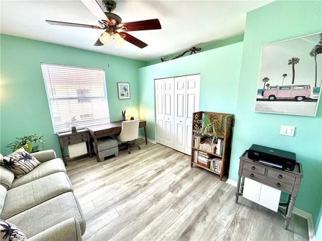 Office with light hardwood / wood-style floors and ceiling fan