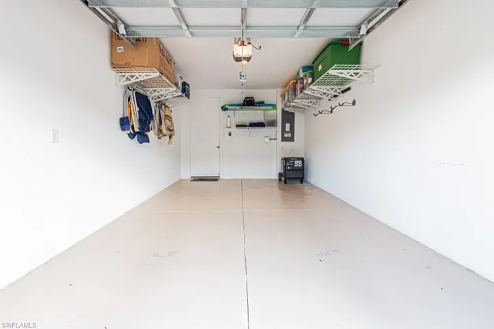 Garage featuring electric panel and a garage door opener
