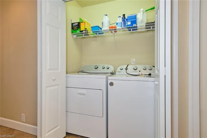 Laundry room with washer and dryer and light tile patterned floors