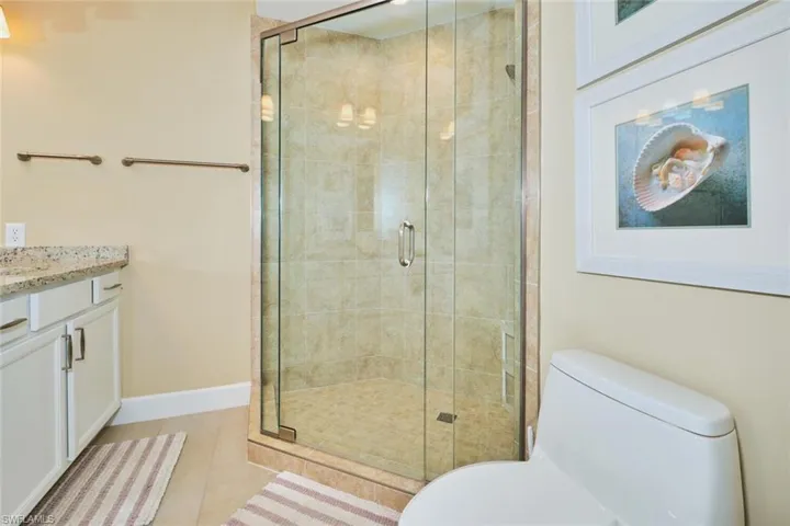 Full bathroom with light tile patterned floors, vanity, and a stall shower