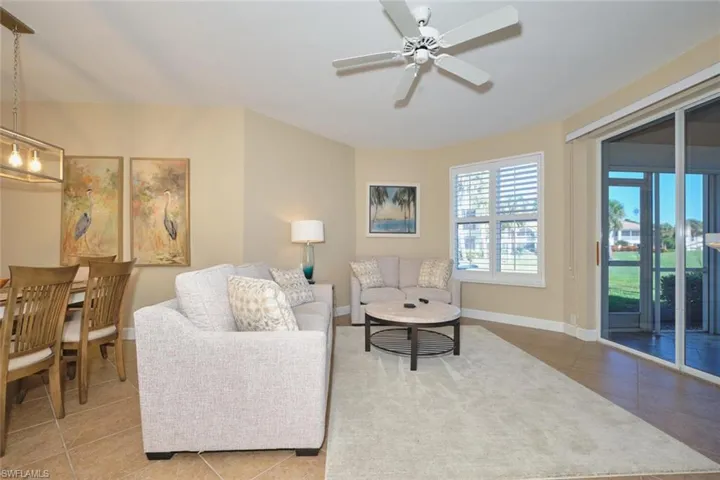 Living area with tile patterned floors and a ceiling fan