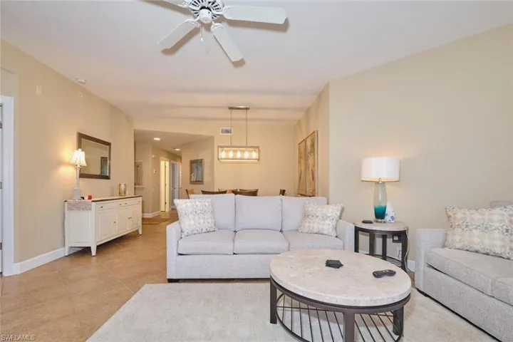 Living room with ceiling fan and light tile patterned floors