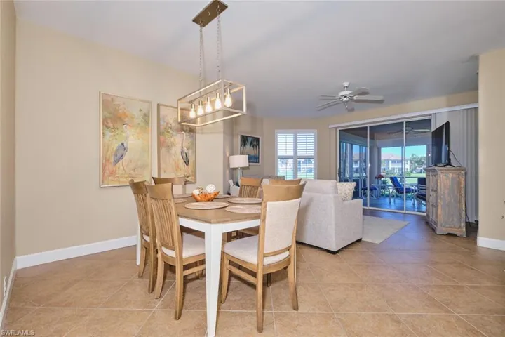 Dining space featuring light tile patterned flooring and a ceiling fan