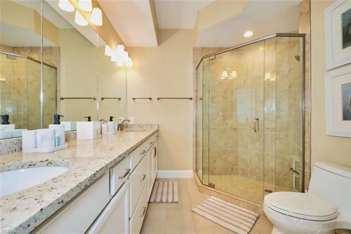 Full bathroom with light tile patterned floors, double vanity, a shower stall, and recessed lighting