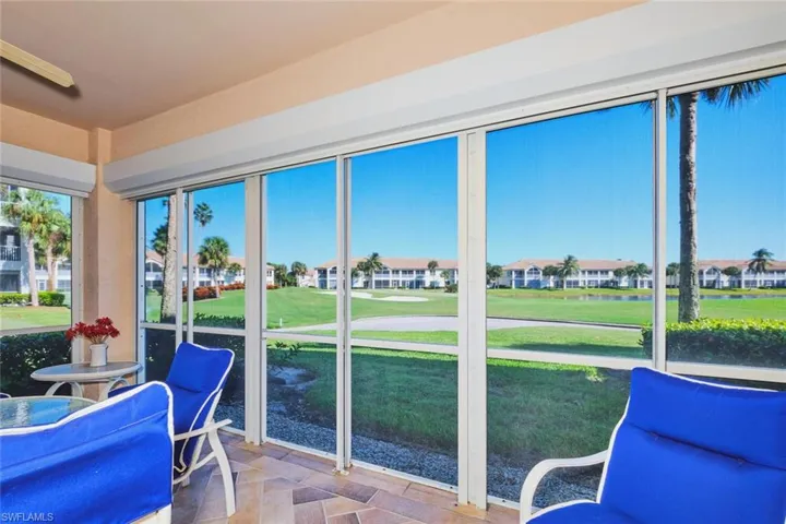 Sunroom / solarium with view of golf course and a water view