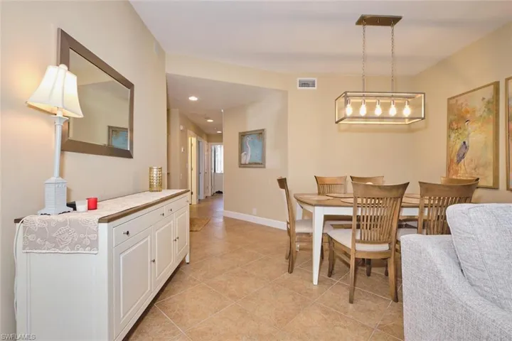 Dining space with light tile patterned floors and recessed lighting