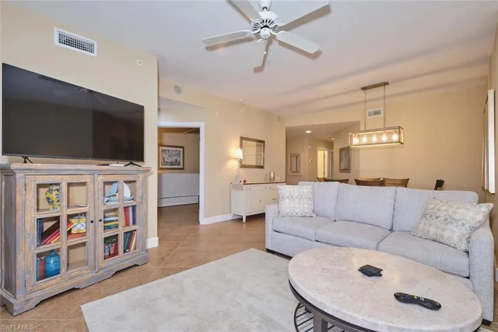 Living room featuring light tile patterned floors and a ceiling fan