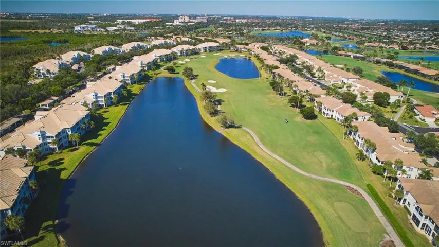 Aerial view of property and surrounding area featuring nearby suburban area and a golf club