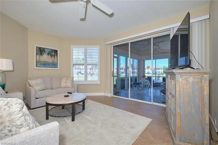 Living room with tile patterned floors and ceiling fan
