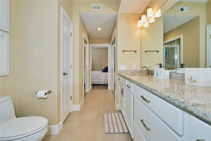 Ensuite bathroom featuring vanity, light tile patterned flooring, and recessed lighting