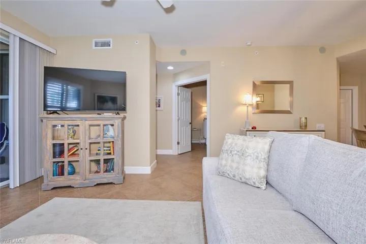 Living room with light tile patterned floors and ceiling fan