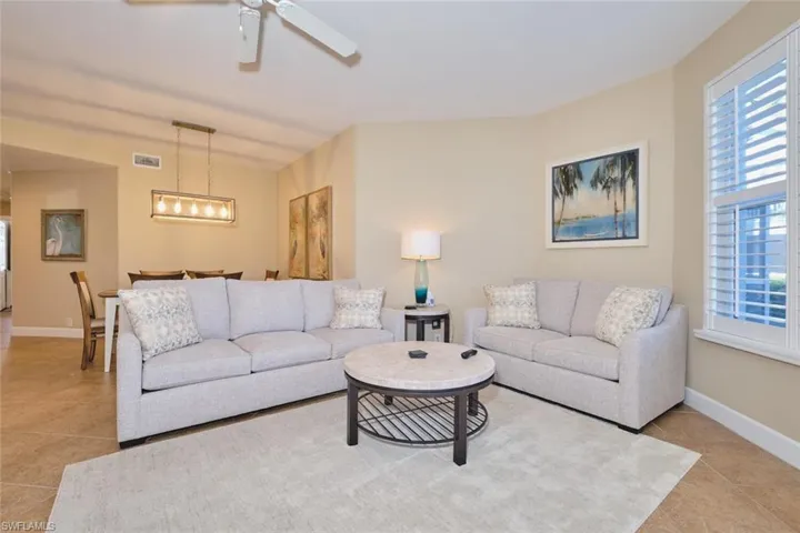 Living area featuring light tile patterned flooring and ceiling fan
