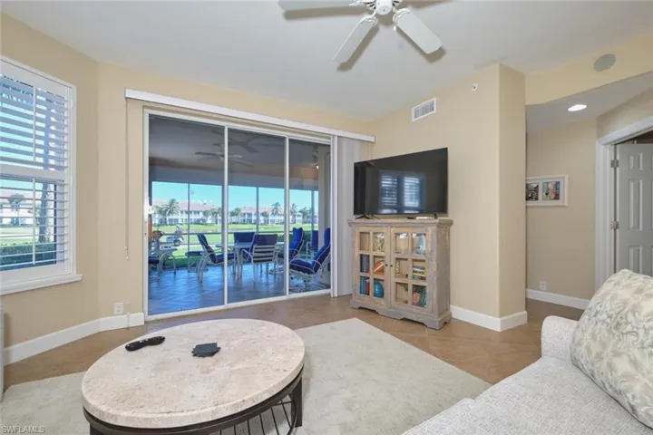 Living area featuring a ceiling fan and tile patterned flooring