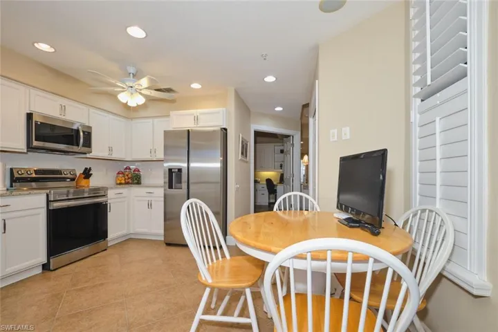 Kitchen featuring appliances with stainless steel finishes, recessed lighting, white cabinetry, light tile patterned floors, and light stone countertops
