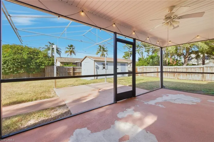 Unfurnished sunroom with ceiling fan and a patio area