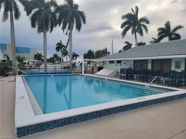 Community pool surrounded by palm tress