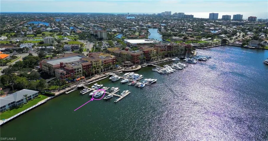 Aerial view of property and surrounding area featuring nearby urban area and a large body of water