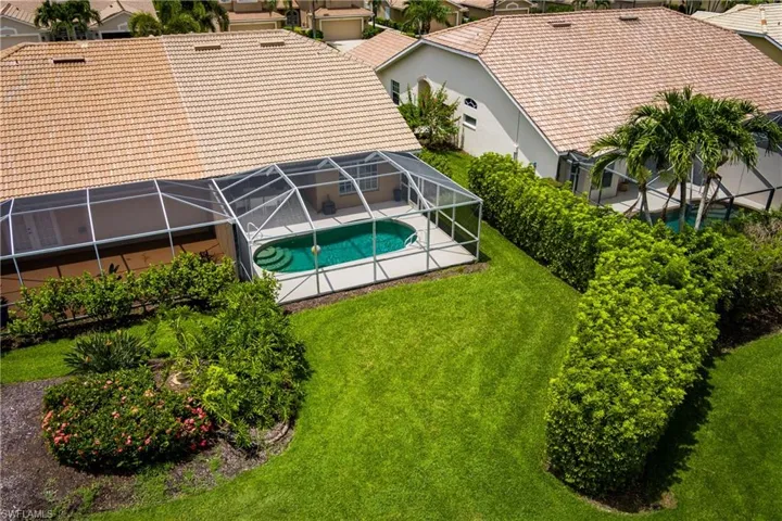 Screened-in pool deck featuring a lagoon-style pool with integrated steps