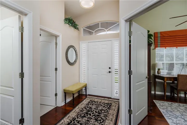 Entry foyer with wood-finish flooring and a decorative area rug