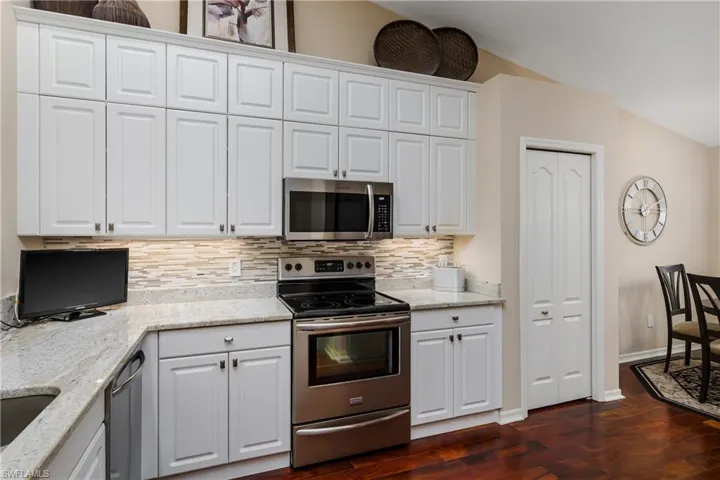 Kitchen with white shaker-style cabinetry, light-toned countertops, and stainless steel appliances