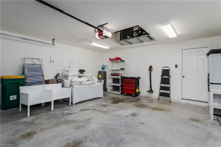 Spacious garage featuring a concrete floor, white walls, and bright overhead strip lighting