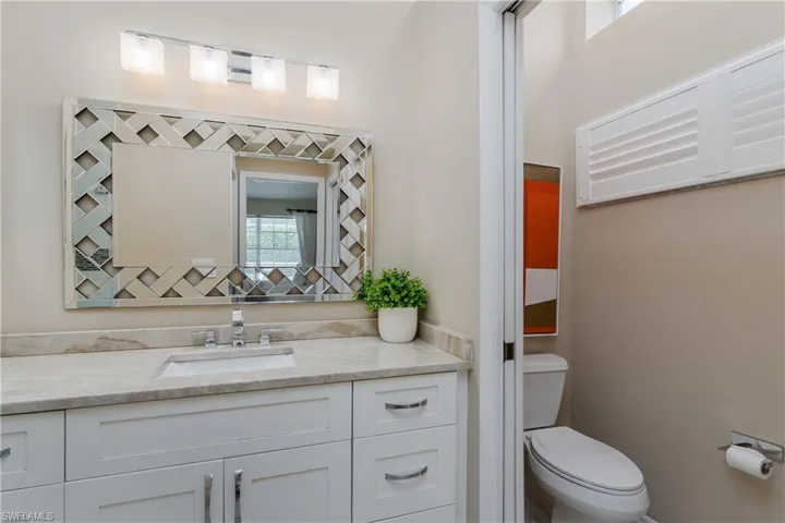Vanity with a white shaker-style cabinet, integrated sink, and light-toned countertop