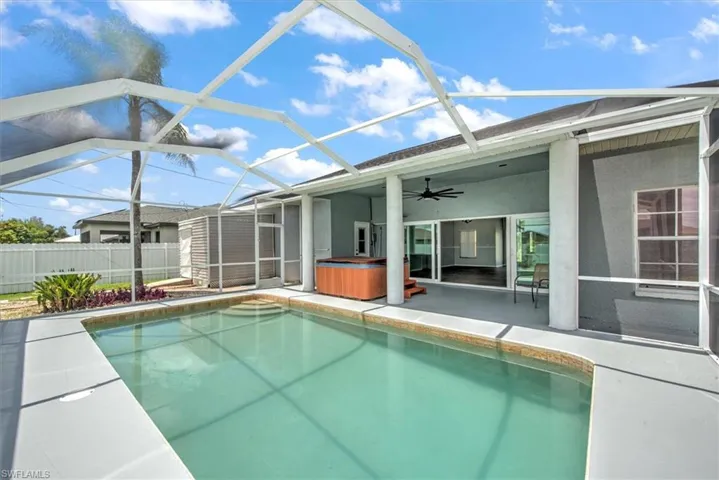 View of swimming pool with a lanai, a hot tub