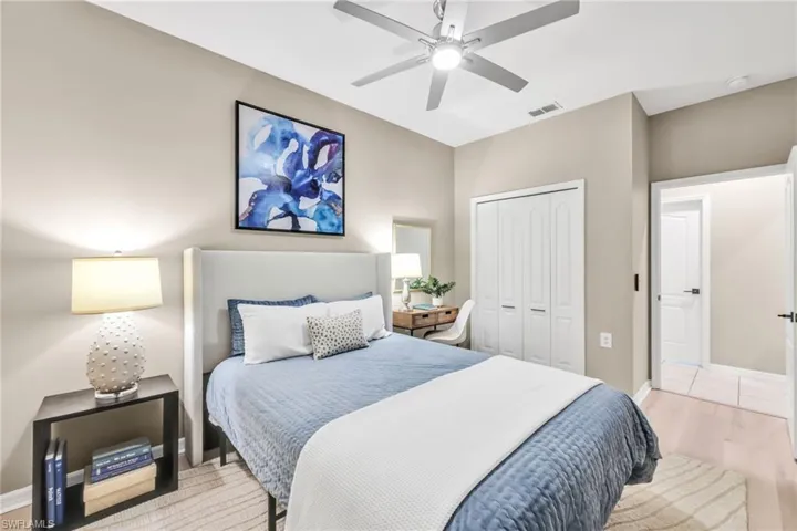 Guest bedroom with updated luxury flooring, neutral walls, modern ceiling fan - a private guest suite with bathroom (and laundry) with pocket door that closes guests off if they need privacy.