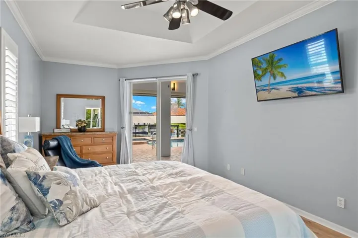 Bedroom featuring ceiling fan, light hardwood / wood-style flooring, ornamental molding, and access to exterior