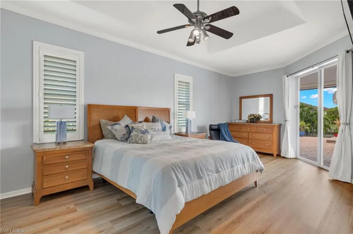 Bedroom with ceiling fan, access to outside, ornamental molding, and light hardwood / wood-style floors