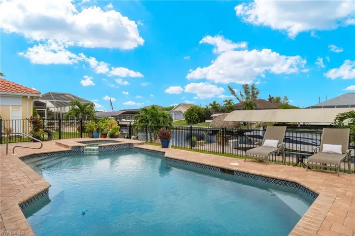 View of swimming pool with a lanai, an in ground hot tub, and a patio