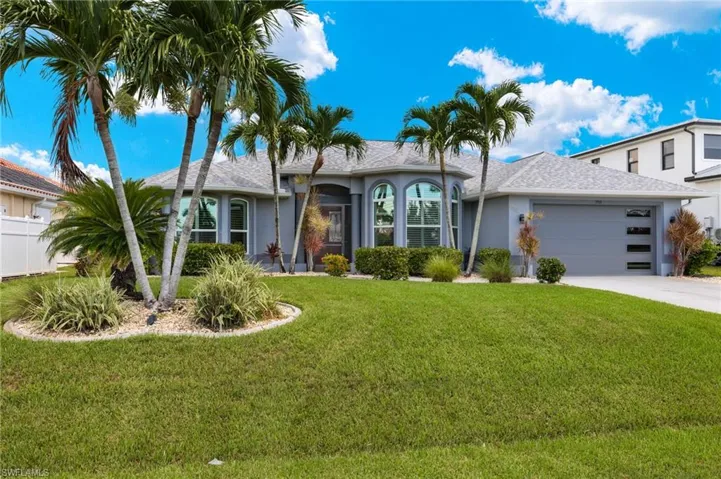 Single story home featuring a front yard and a garage