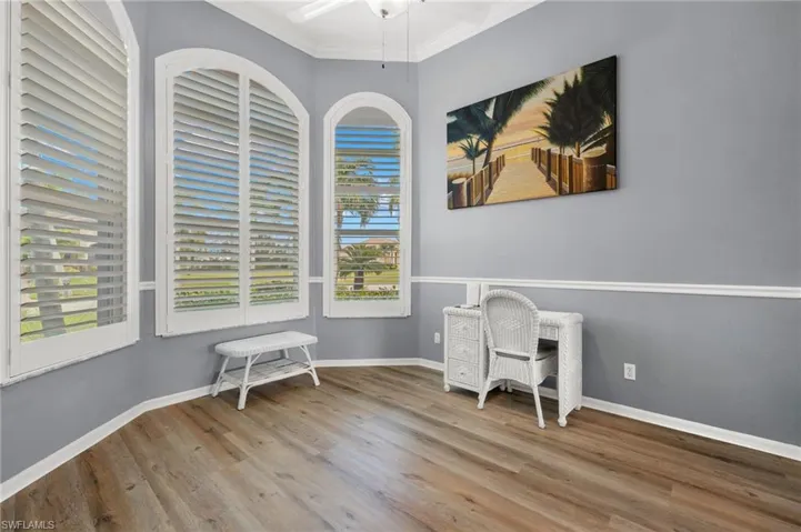 Unfurnished office with ornamental molding, wood-type flooring, and a wealth of natural light
