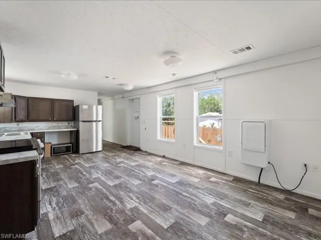 Kitchen with visible vents, stainless steel appliances, dark wood-style flooring, and dark brown cabinetry