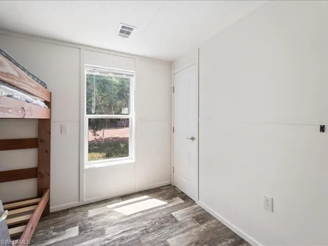 Unfurnished bedroom featuring visible vents and wood finished floors