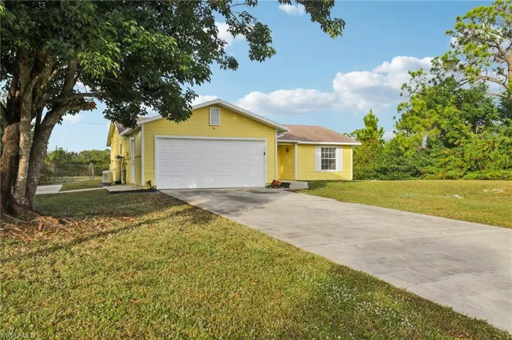 View of front of house featuring driveway, a front lawn, and a garage