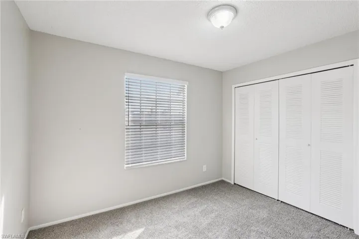 Unfurnished bedroom with carpet flooring, a textured ceiling, and a closet