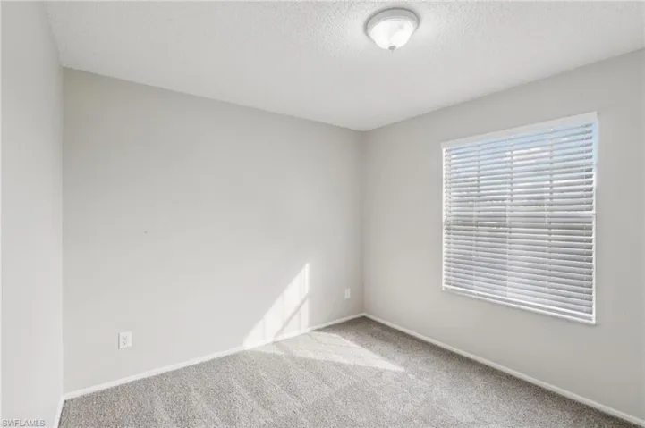Spare room featuring carpet and a textured ceiling