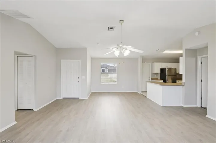 Unfurnished living room featuring light wood-type flooring and ceiling fan