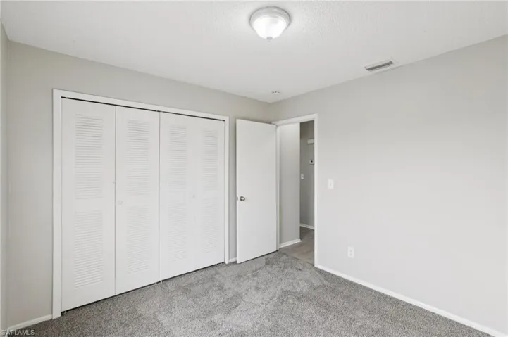 Unfurnished bedroom with carpet flooring, a closet, and a textured ceiling