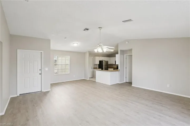 Unfurnished living room featuring a ceiling fan and light wood-style floors