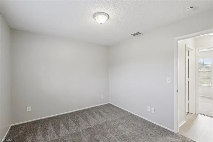 Spare room with carpet floors and a textured ceiling