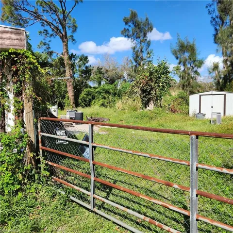 View of gate featuring a lawn and a shed
