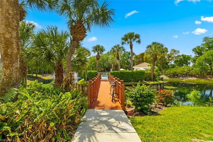 Community Cabana Pool with a water view, a patio area, and view of wooded area
