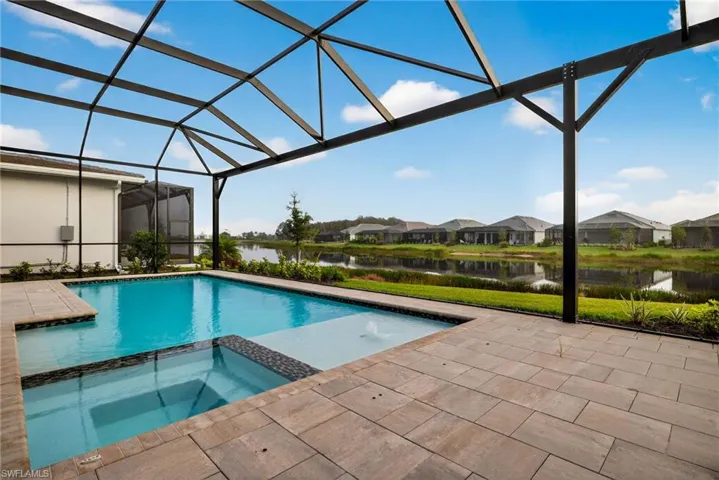 View of swimming pool featuring a water view, a pool with connected hot tub, a sunroom, a lanai, and a residential view